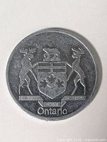Obverse of aluminum medallion showing Ontario coat of arms