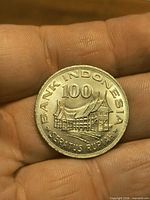 Obverse of 1978 Indonesian 100 Rupiah coin showing Rumah Gadang building and inscriptions