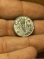 Reverse of 1945 Canadian V nickel showing torch and year