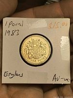 Reverse view of 1983 £1 coin in holder showing crowned Royal Arms