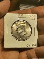 Obverse of 1991 Kennedy half dollar in 2×2 flip showing date and Kennedy portrait