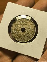 Obverse showing oak branch motif, denomination 25 CEN and central hole