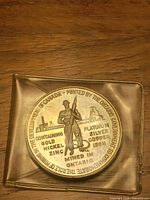 Obverse showing miner figure, metal composition text, 2-inch poly holder
