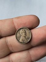 Obverse of 1927-D Lincoln Wheat Cent on fingertips