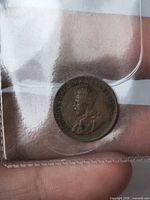 Obverse of 1935 Canadian 1¢ coin showing King George V inside plastic holder