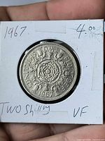 Obverse view of 1967 two shillings coin showing reverse floral design and date, coin in 2x2 holder