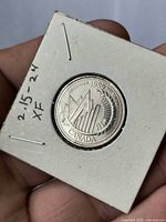 Reverse view of 1999 Canada quarter in 2x2 holder showing December 1999 millennium design and Extra Fine notation