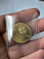 Reverse showing maple leaf, Olympic rings, 2004 date, Coca-Cola script