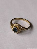 Ring front view showing blue center stone and clear accents