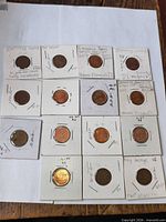All 13 Canadian 1-cent coins in individual 2×2 holders displayed on sheet