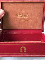 Interior view showing gold Omega Constellation inscription and beige lining