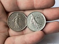 Obverse of both 5 francs coins in hand, showing Sower design