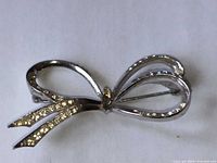 Front view of silver-plated rhinestone bow brooch