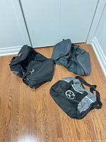 All three bags laid out on floor showing colors, logos, straps and overall condition