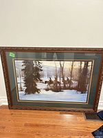 Full view of framed artwork standing on floor showing frame, matting and image