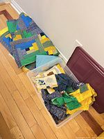 Plastic bin showing quilt sections and loose fabric pieces