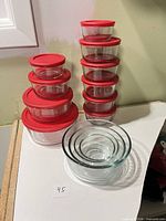 Group of Anchor clear glass food storage containers with red lids and set of nesting glass bowls