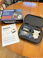 Open hard case showing laser level, mounting base, accessories and manual beside it