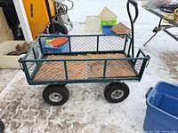 Side view of green steel mesh garden wagon on pneumatic tires