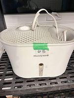 Front and top view of Honeywell humidifier showing brand logo, water level window, cord and control dial