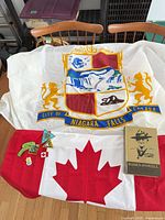 All items laid out: Niagara Falls flag, Canadian flag, book, five patches
