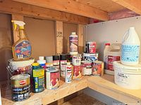 Wide view of assorted paint cans, cleaners and chemicals on shelf