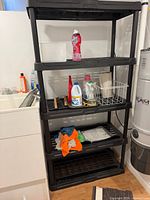Full view of black plastic shelving unit with five shelves