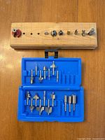 Overall view of wooden holder with individual bits and closed blue case