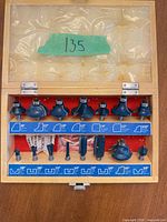 Open case displaying 15 router bits, profile chart and shank size