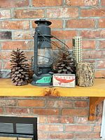 Full lot view showing lantern, pinecones, matches, log piece, plaid pillar accent