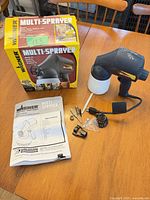 Full lot showing sprayer, box, manual and accessories on table