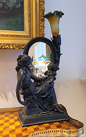 Full view of figural lamp with mirror and glass shade