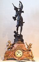 Full view of mantel clock showing bronze figure, marble base, cherubs, and dial
