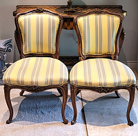 Full view of both carved wood accent chairs side by side