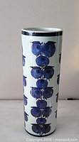 Full front view of cylindrical vase showing blue fruit motif