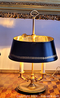 Front view of gilt brass bouillotte lamp with black tole shade