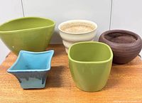Five assorted planters grouped together