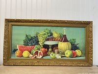 Full view of framed still-life artwork showing ornate gold frame and subject matter