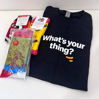 Front view of black T-shirt with text and three pairs of socks