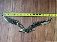 Large brass seagull measured against tape ~12.5 in