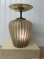 Complete ceiling light assembled showing frosted glass shade and brass canopy