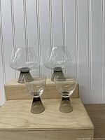 Full set showing two snifters and two aperitif glasses on display blocks