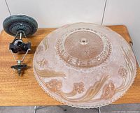 Glass ceiling light shade with attached metal mount on tabletop