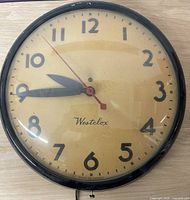 Front view of round Westclox wall clock showing full dial, numerals, and red second hand