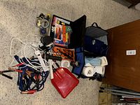 Pile showing jumper cables, power strip, cords, snow shovel, tool bag and toolbox
