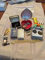 Overall view of jewelry, coins, bracelet, brooches, earrings, bar and trinket box