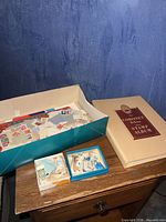 Album and three boxes containing loose postage stamps displayed on tabletop