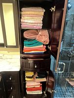 Cabinet shelves showing stacks of assorted colored towels