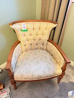Front view of French-style wooden armchair with tufted floral upholstery