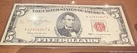 Front of 1963 red seal $5 bill in plastic sleeve